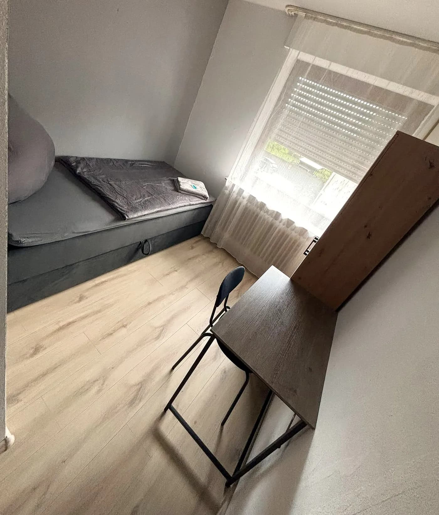 Renoviertes Einzelzimmer mit hellem Holzboden